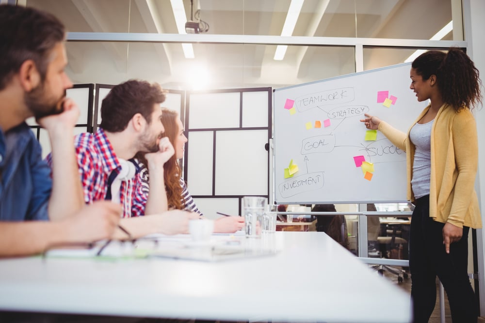 Young female executive explaining colleagues at creative office